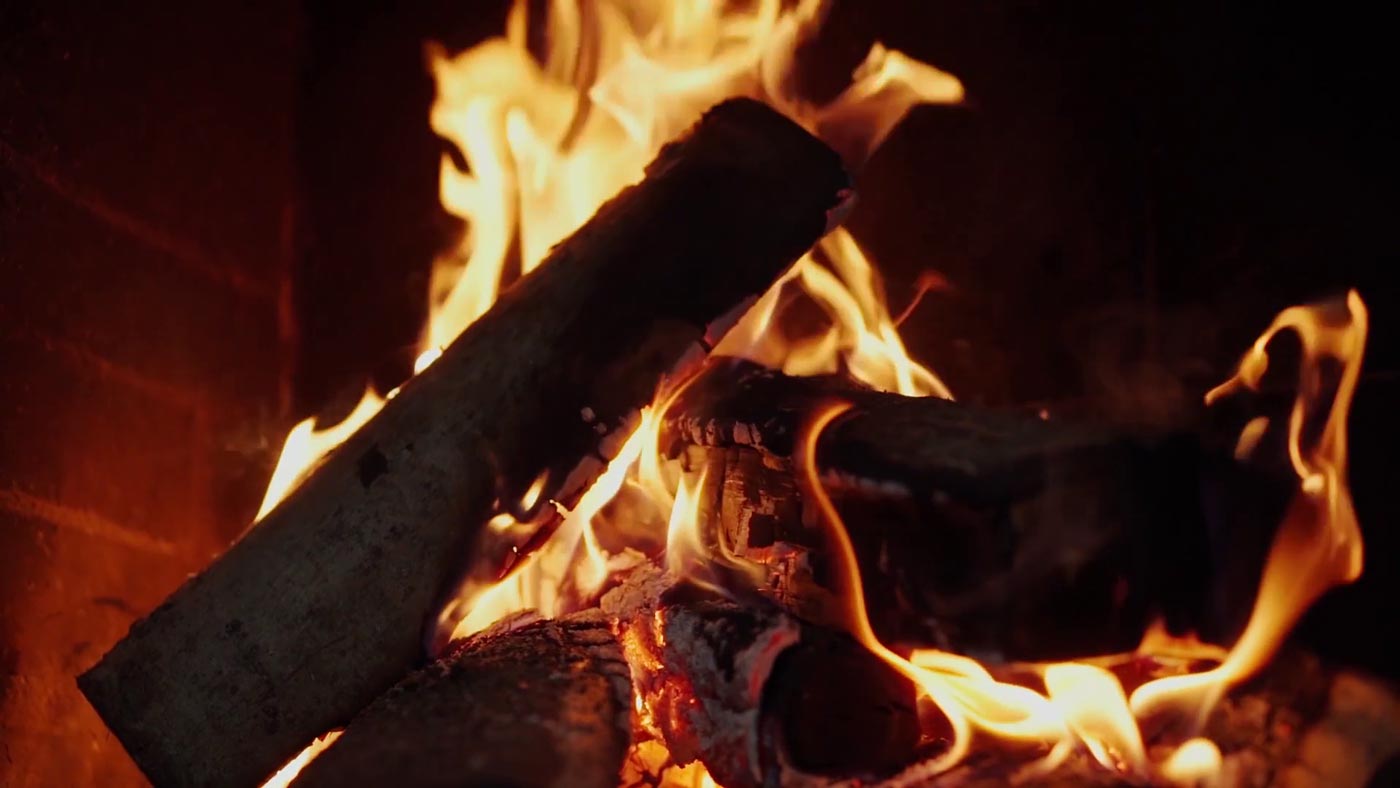 Logs burning in Izzy's Double-Barrel Trailer Smoker